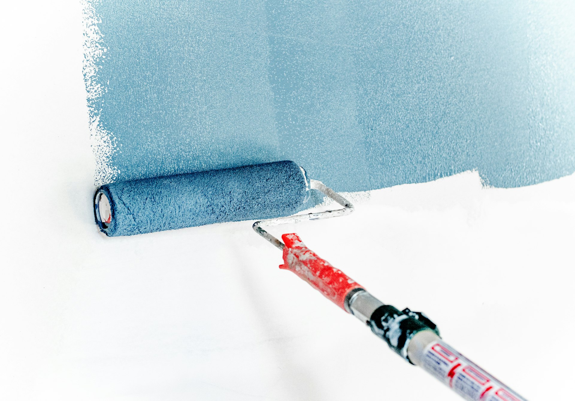 Paint roller applying a coating to a wall